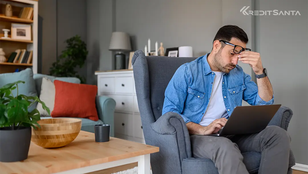 Homeowner stressed by rising taxes and insurance premium works on laptop